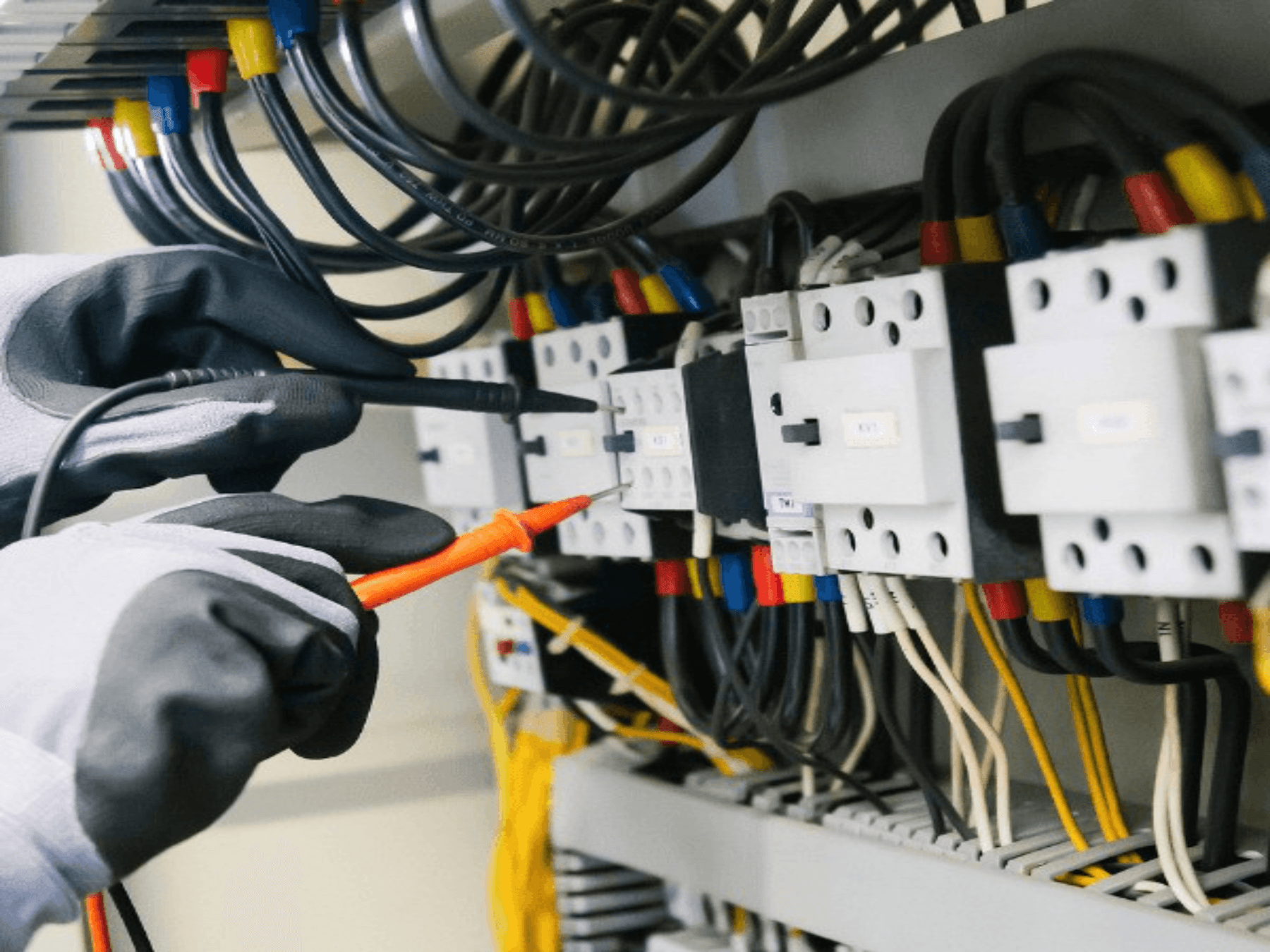 Electrician testing a distribution panel with a multimeter